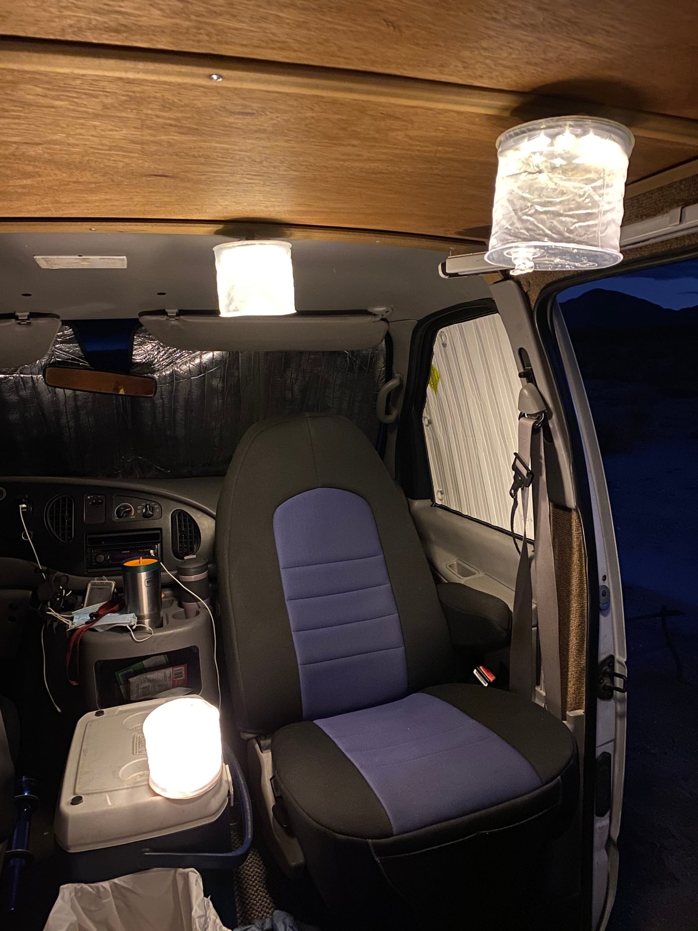 Inside an RV rental: a cozy night scene with the driver's seat, dashboard, and DIY hanging lights for ambient travel lighting. — photo 11