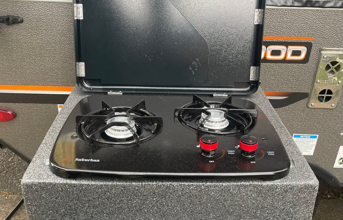  with a "Happy Camper" coaster above.|RV rental kitchen: camping dinnerware
