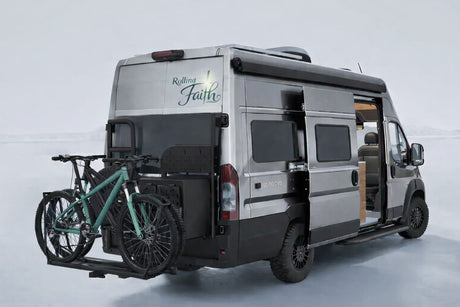 "Rolling Faith" custom camper van RV rental with bikes on back, side door open. Ideal for off-road travel and adventure.