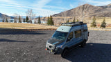 This adventure-ready Mercedes Sprinter van, ideal for your next RV rental, parked by a scenic lake and mountains.
