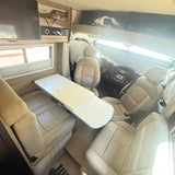 Comfortable rv rental interior: cream seating, dining table, and driver's cabin. Ideal camper living space.