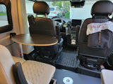 Rv rental interior: swiveling front seats, a removable table, and a compact workspace, great for mobile living.