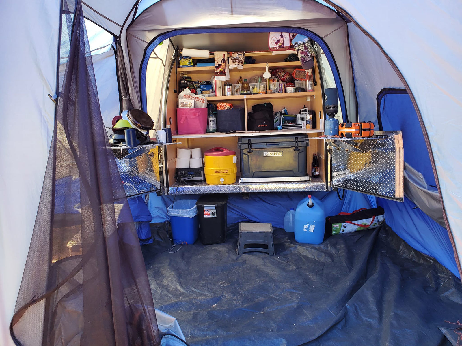 Inside a spacious RV rental annex, showcasing an organized camp kitchen with a YKO cooler and Jetboil. Ready for adventure!