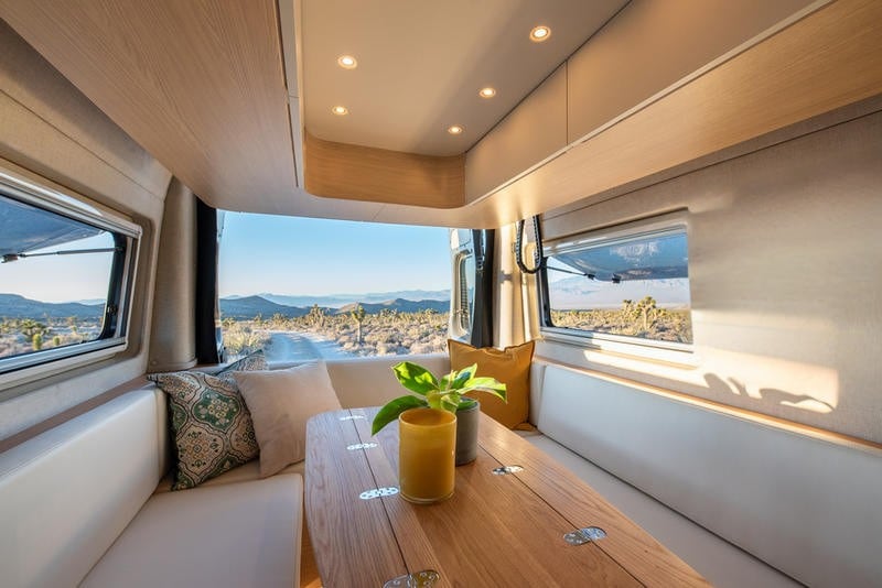  and a wall-mounted TV.|RV rental: Open doors reveal the custom wood interior of a camper van — photo 11