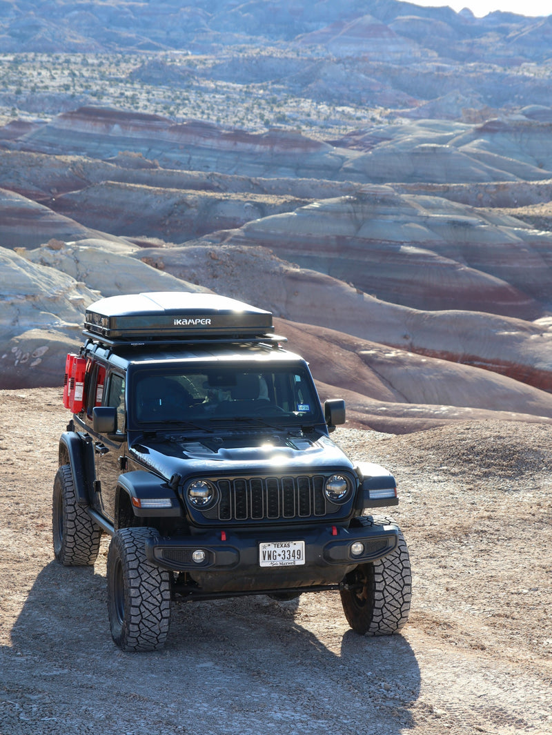  ready for an off-road rv rental adventure.|Black Jeep Wrangler with iKamper rooftop tent on a dirt road — photo 2