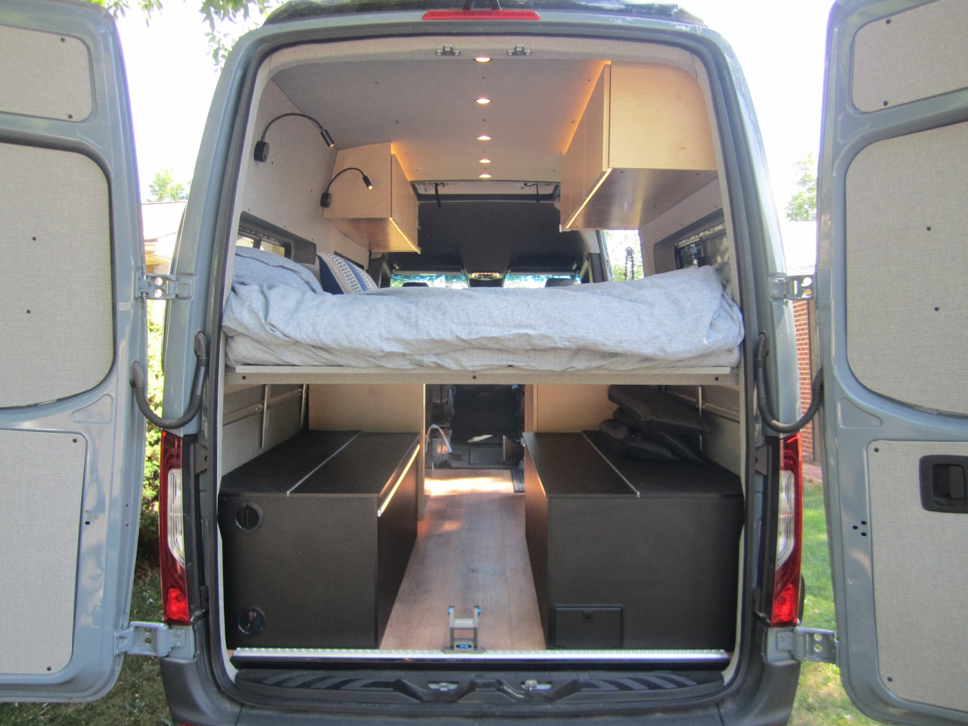  and dinnerware displayed on an outdoor counter.|This RV rental camper van features a compact kitchen inside & a convenient fold-out outdoor table for coffee time.|RV rental kitchen drawer — photo 17