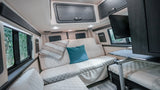 Enjoy travel comfort in this RV rental's interior: plush quilted seating, smart storage, and a mounted TV for mobile living.