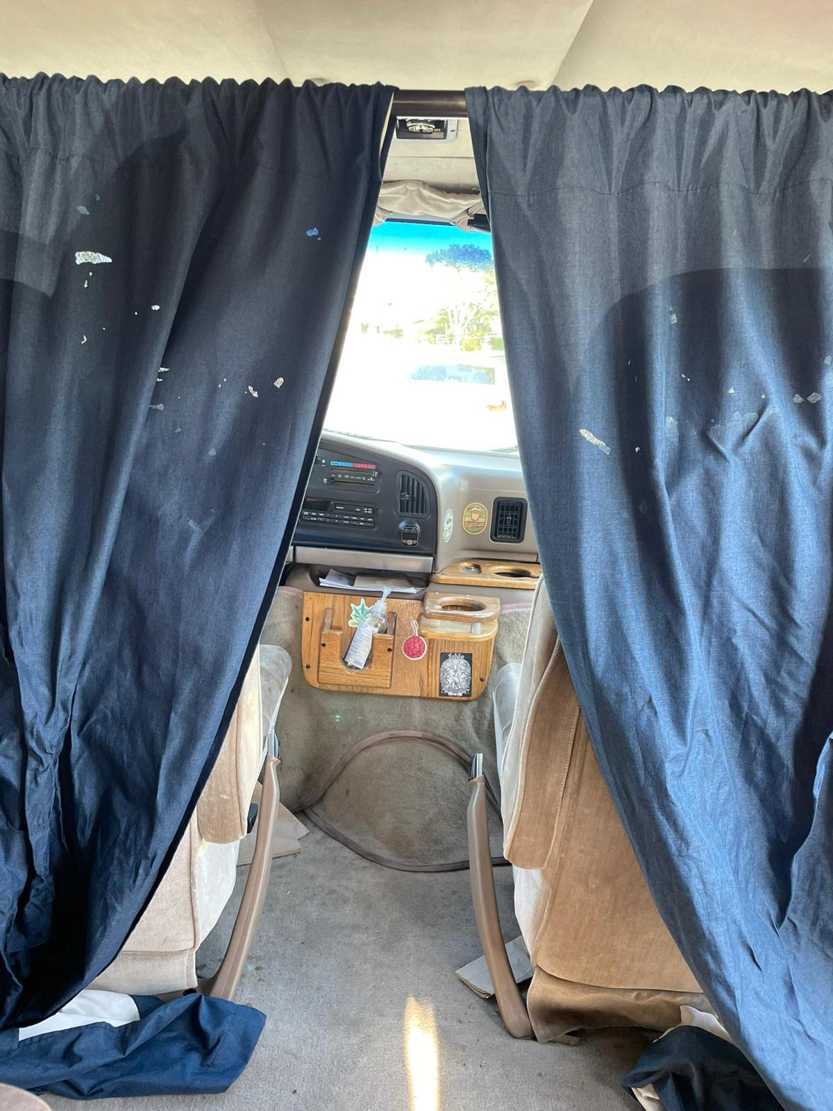 an RV rental. Parked under sunny skies near palm trees.|RV rental interior featuring a comfy quilted bed — photo 7