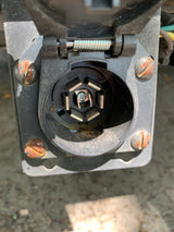 Close-up of a rusty 7-pin trailer connector on a vehicle, essential for rv rental towing.