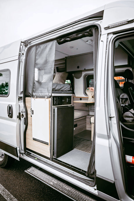 Step inside this RV rental! A well-designed camper van interior reveals a bed, living space, and amenities for your road trip.