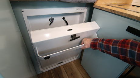 This RV rental features a compact pull-down wash station with a faucet and hose, maximizing space for convenient mobile living.