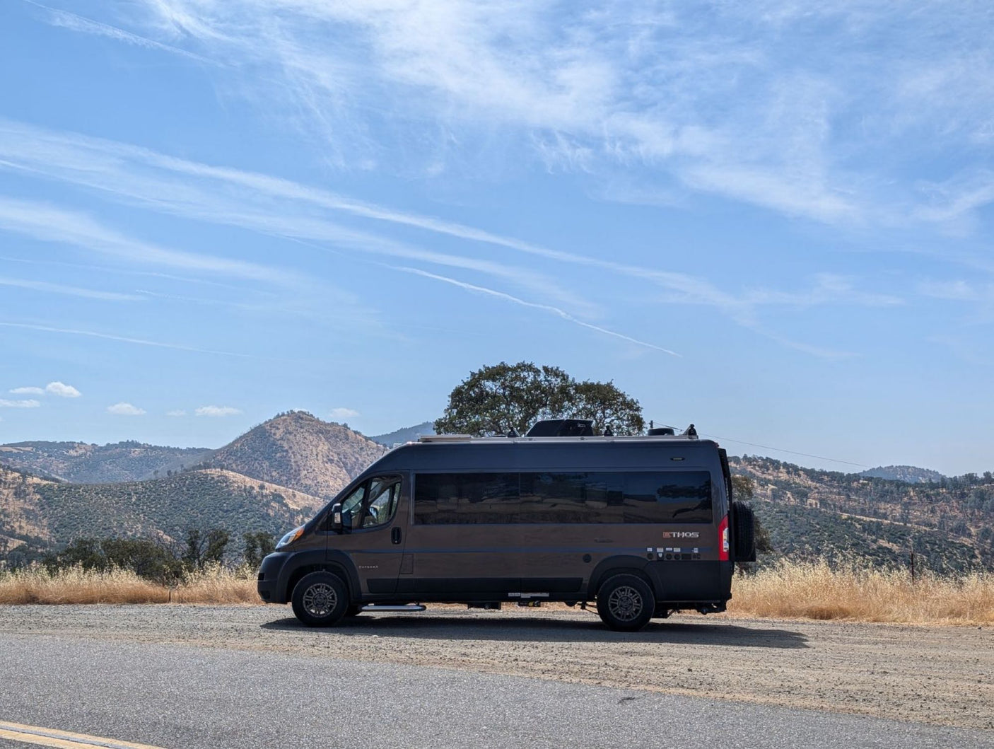 Thor Ethos camper van parked on a scenic mountain road. This dark grey RV rental is ready for adventure!