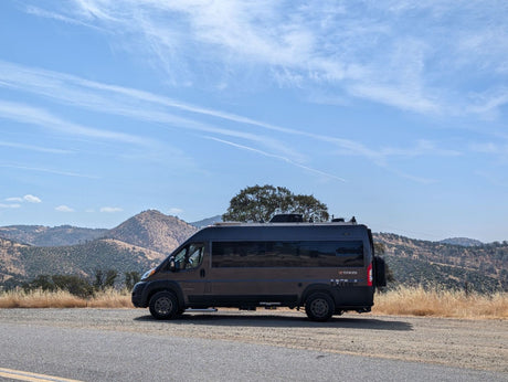 Thor Ethos camper van parked on a scenic mountain road. This dark grey RV rental is ready for adventure!
