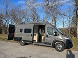Gray Winnebago Solis camper van for RV rental, parked outdoors with doors open, showcasing its modern interior.