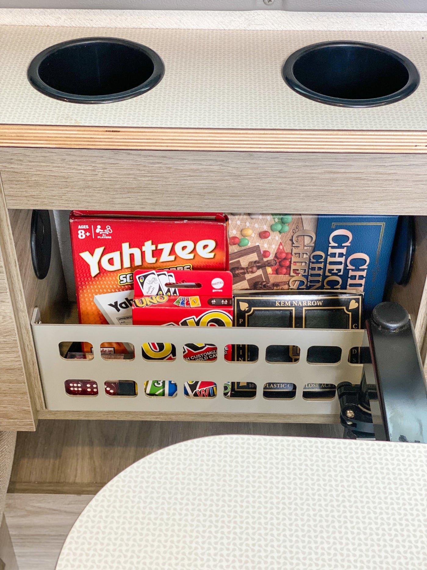 RV rental interior: Built-in cup holders & a pull-out basket brimming with board games like Yahtzee and UNO for trips. — photo 18