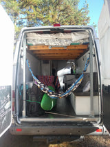 Adventure-ready RV rental interior: elevated bed, hammock, and storage for outdoor gear, offering a compact, cozy van life.