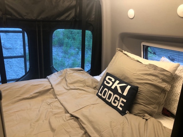  and a partly cloudy sky.|Discover this RV rental's efficient interior: a compact kitchen with covered stovetop/sink — photo 7