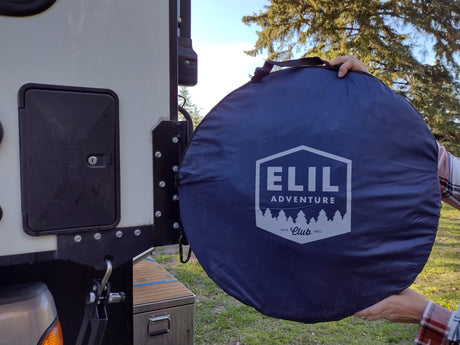 Unpacking an Elil Adventure portable shower tent by an RV rental's exterior shower panel. Perfect for camping!