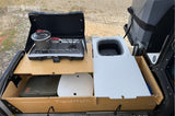 Compact RV rental outdoor kitchen: pull-out stove with pot, collapsible sink, and storage drawers for convenient camping.