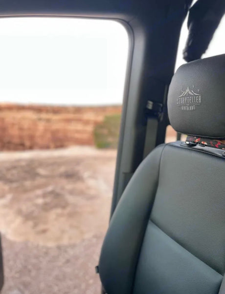 Inside an RV rental, looking out at the vast overland landscape. Storyteller Overland seat visible.