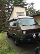 Brown VW Westfalia pop-top camper van with PNW decal. An ideal rv rental for outdoor adventures.