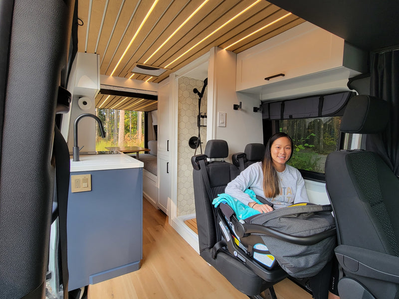 Modern RV rental: woman & baby in comfy seats, full kitchen & tiled shower. Ideal for family travel adventures. — photo 5