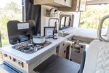 This rv rental offers a fully equipped compact kitchen with a stove, sink, wine, and a cozy bed, perfect for your next adventure.