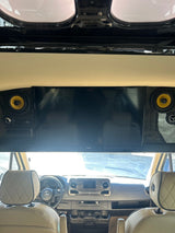 RV rental: Luxurious Mercedes cockpit with custom TV and vibrant yellow-coned speakers, viewed from the rear passenger area.