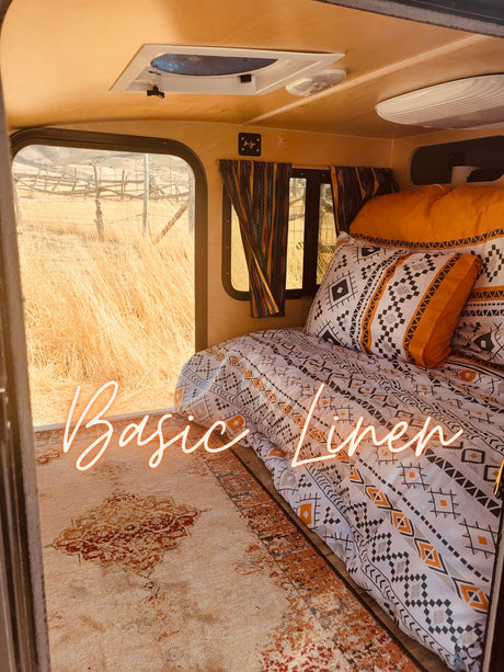 Step into this cozy RV rental! Enjoy patterned bedding, a soft rug, and scenic golden field views through the window with our "Basic" linen package.