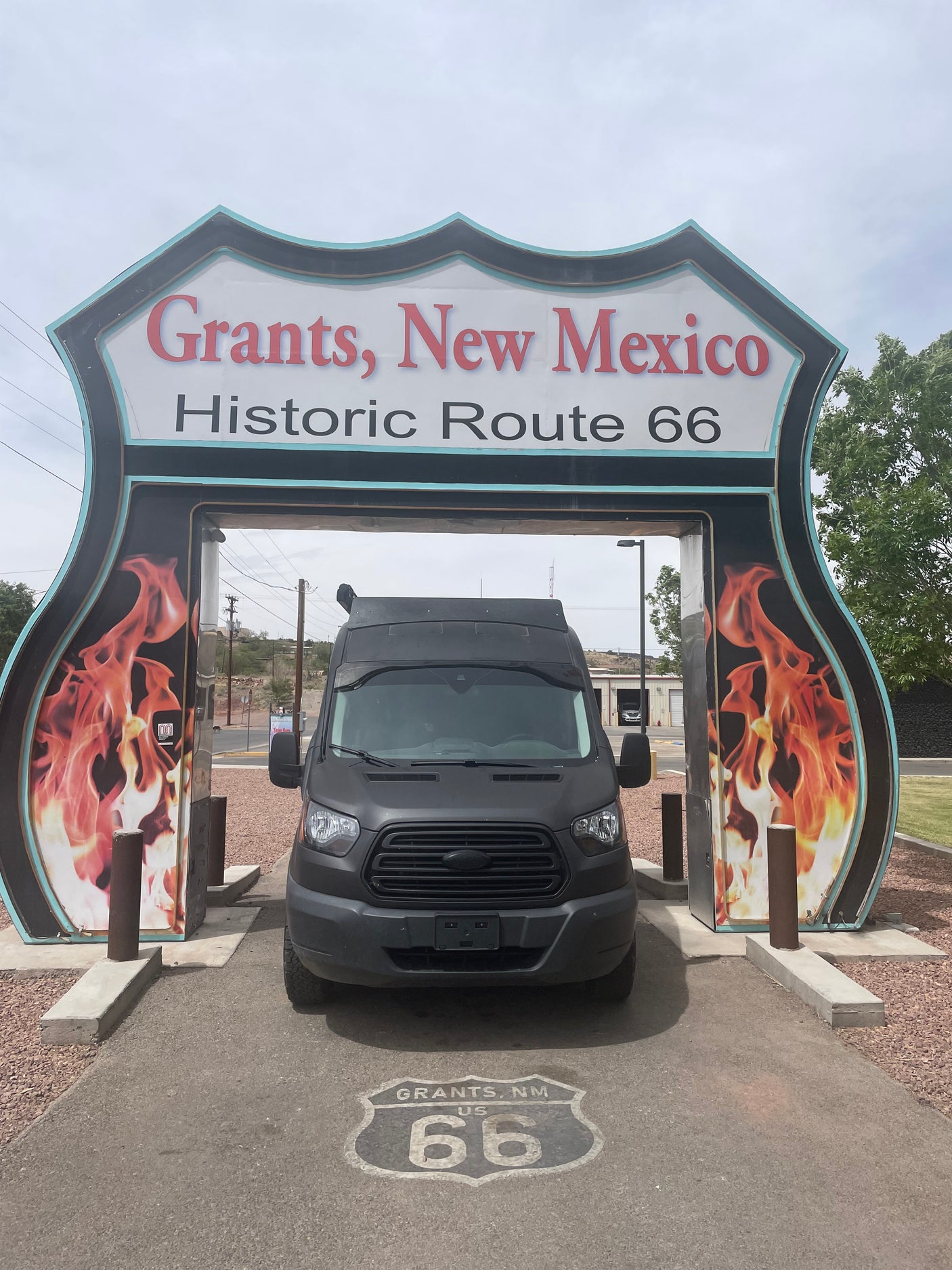 RV rental van at Historic Route 66 entrance in Grants, New Mexico. A dark van is parked under the iconic shield sign.