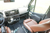 Spacious RV rental cockpit: modern dashboard, large display screen, and comfortable brown leather quilted seats for an enjoyable drive.