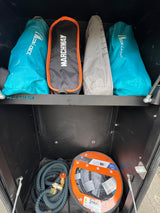 RV rental storage: compact camping chairs, coiled water hose, and SmartPlug power cord, neatly packed for your trip.