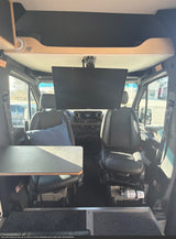 Inside this rv rental: Swivel front seats, an attached table, and a ceiling-mounted Sylvox TV in a Mercedes-Benz camper van.