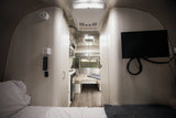 Inside this modern RV rental, find a comfortable bed, compact kitchen, dinette, and TV for your travels.
