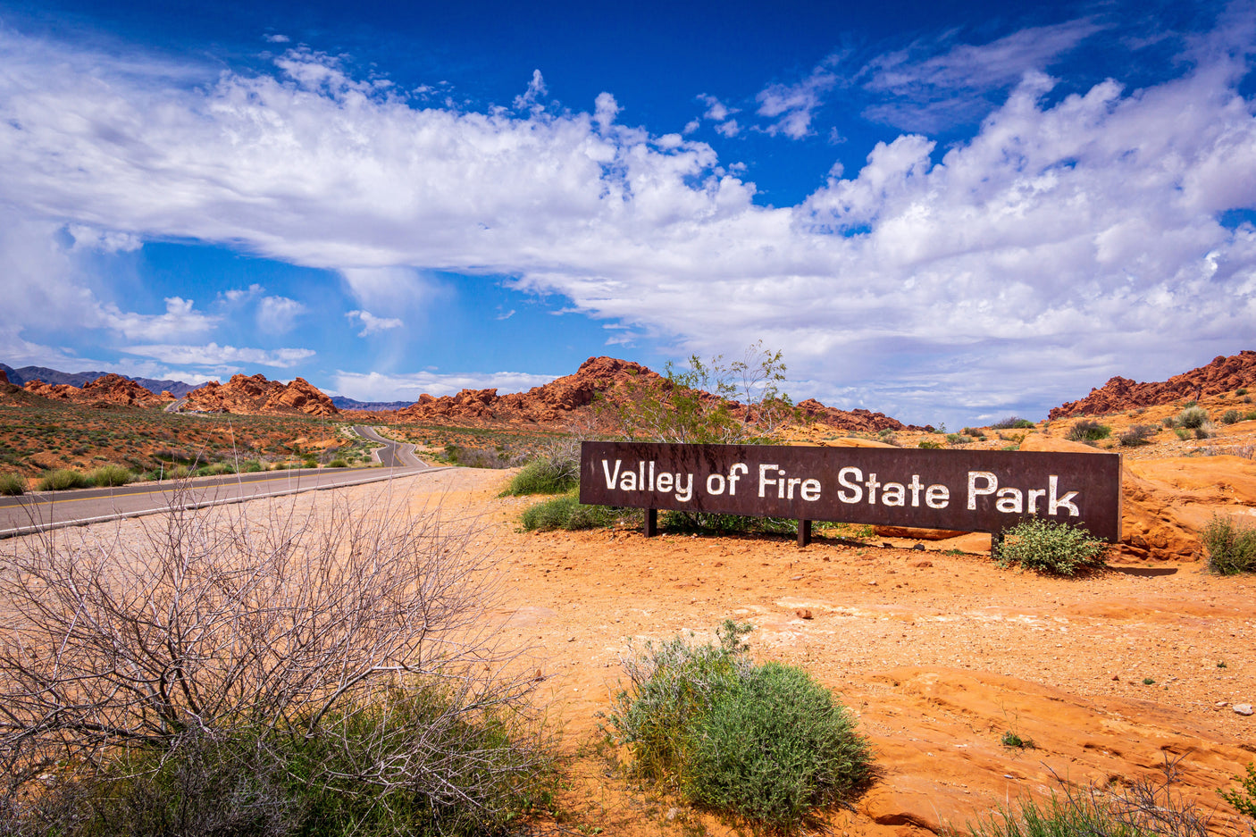 Valley of Fire State Park entrance sign, ideal for rv rental road trips through red rock desert landscapes under a bright sky.