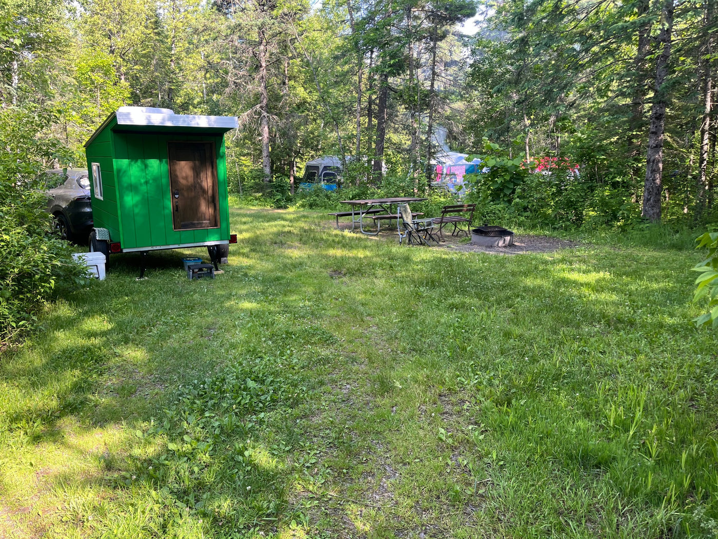  ready for your next adventure.|Gray SUV towing a bright green custom camper trailer on a driveway. Imagine this for an RV rental adventure!|Bright green custom mobile shelter on a trailer with a roof vent — photo 7