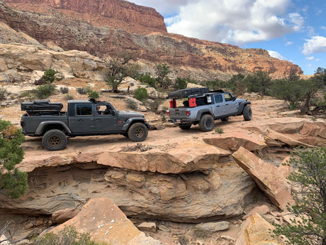 Off-road Jeeps with rooftop tents on a rocky desert trail. Perfect for your next RV rental adventure!