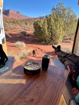 Relaxing in an RV rental with dog & cookies, enjoying stunning desert views, red rocks, & snow-capped peaks. Van life goals!
