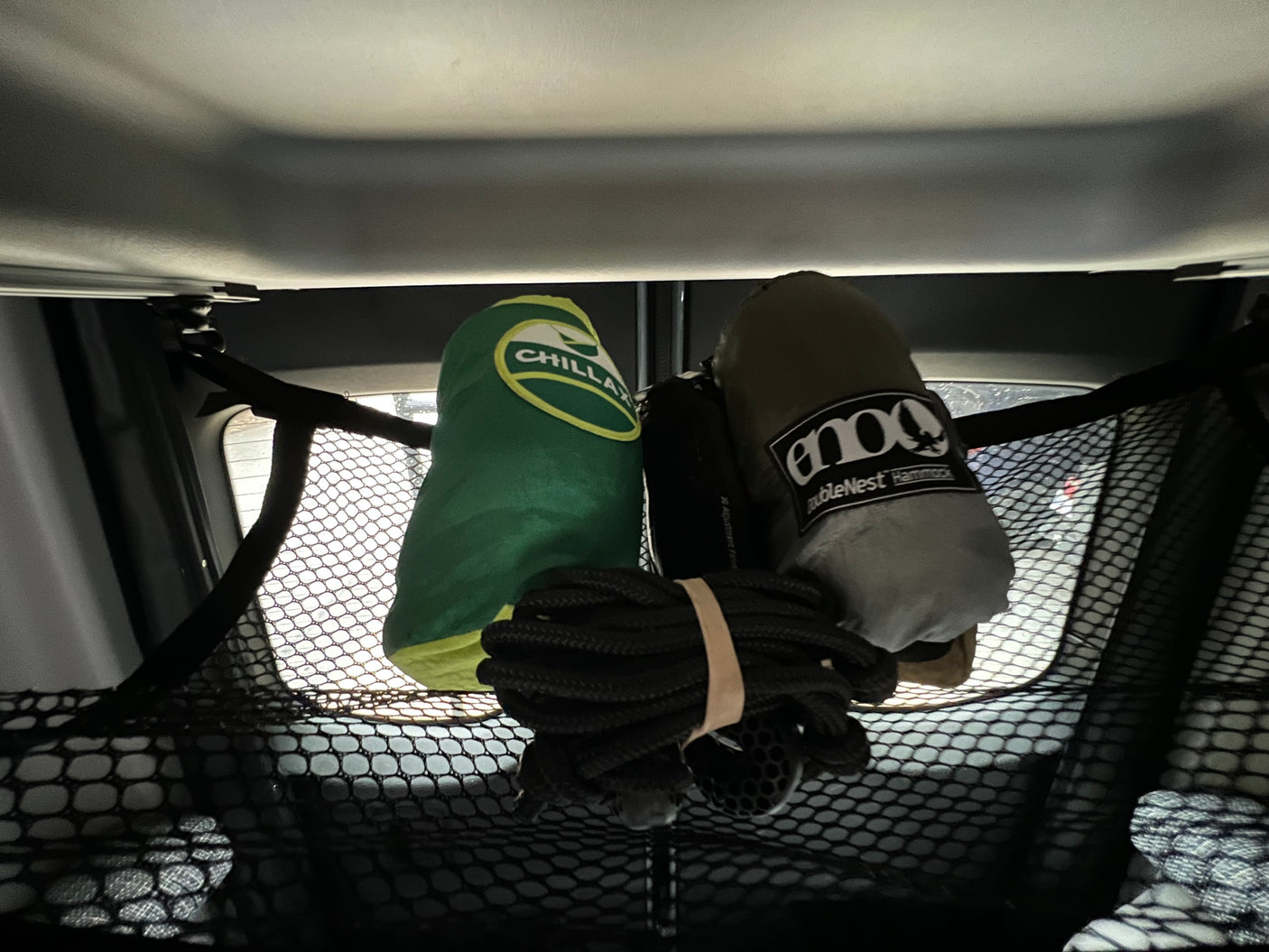 RV rental overhead storage: Chillax & Eno hammocks with rope, secured in a cargo net. Gear organized for travel.