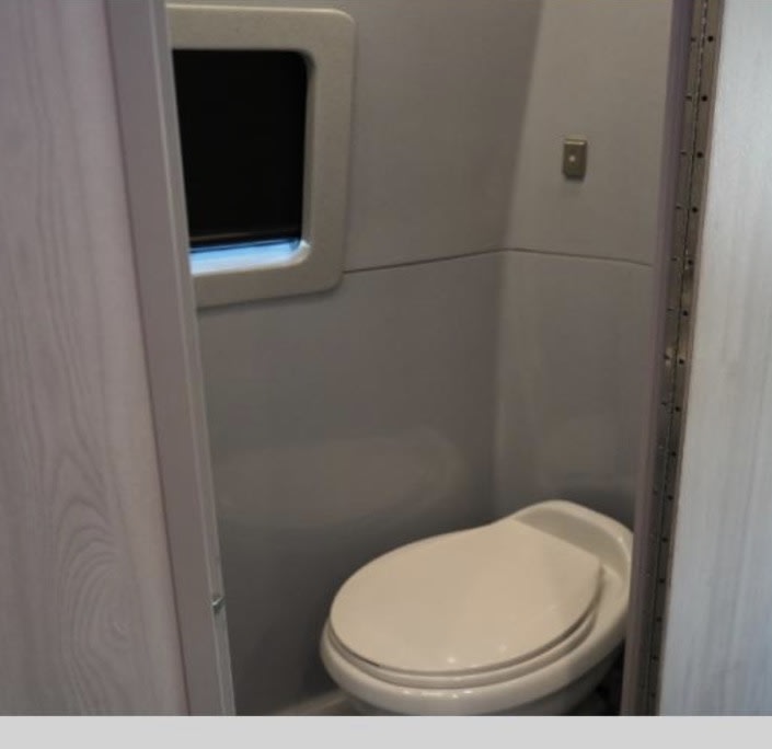  adjacent to a microwave and comfortable seating.|Modern RV rental with a kitchenette: sink — photo 8