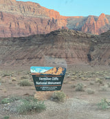 Your rv rental journey begins at Vermilion Cliffs National Monument's welcome sign, surrounded by stunning red rock desert.