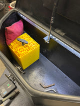 View inside an RV rental storage box containing yellow leveling blocks, a red bag, and a PRO Series Breakaway System.