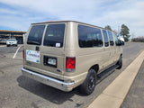Gold Ford E350 Switchback van rental, suitable for RV rental trips, parked in a storage lot.