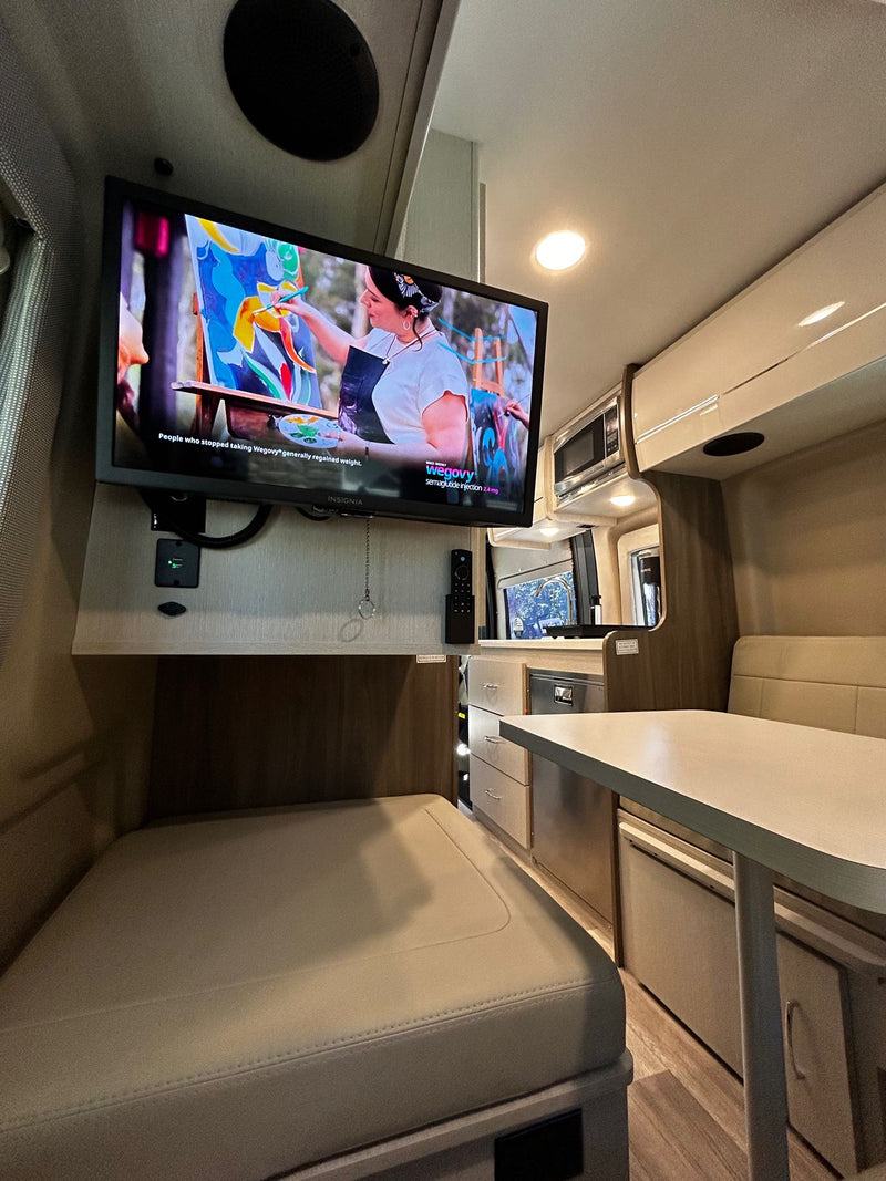  parked on concrete under a blue sky near palm trees.|Compact RV rental wet bath featuring a toilet — photo 6