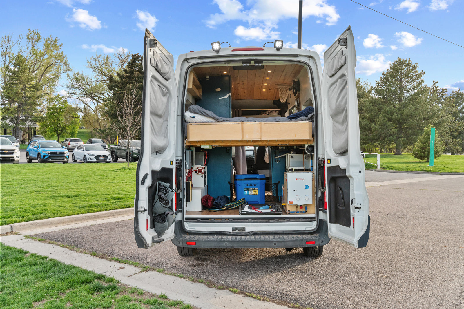 RV rental camper van interior revealed: custom bed, storage, and water heater for off-grid adventures.
