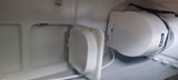 RV rental storage with a secured portable power station (green light visible) and a white charging device connected by a cable.