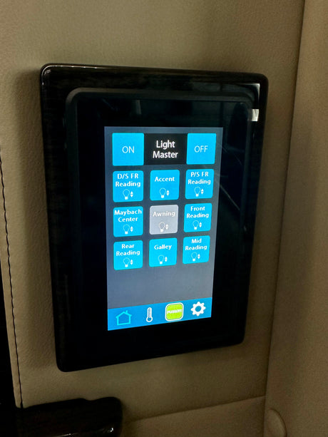 Digital touchscreen light master panel in a luxury RV rental, controlling interior and awning lights for a comfortable journey.