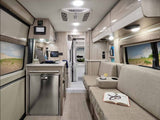 This RV rental offers a compact kitchen, comfy lounge with book/drink, and control panels. Ideal for mobile living.