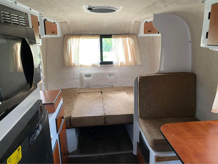  designed for compact living.|Inside an RV rental: upholstered bench