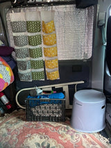RV rental interior: Smart storage with hanging pockets, insulated windows, portable commode, and crate organization.
